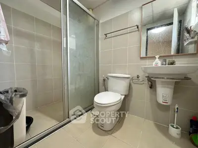 Modern bathroom with glass shower and sleek fixtures in a contemporary apartment.