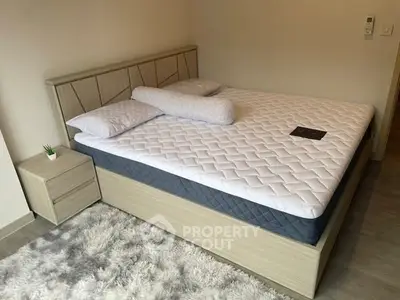 Cozy bedroom with modern bed and plush rug, perfect for relaxation.