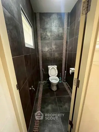 Modern bathroom with sleek dark tiles and compact design