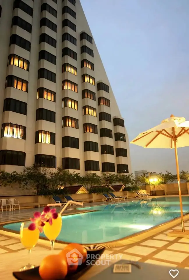 Luxurious high-rise building with inviting poolside ambiance and evening lighting.