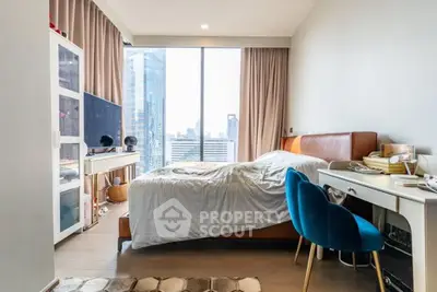 Modern bedroom with city view, stylish furniture, and natural light.
