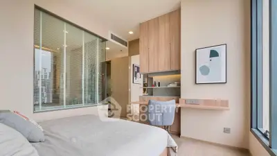 Modern bedroom with stylish decor and built-in desk, featuring large window with city view.