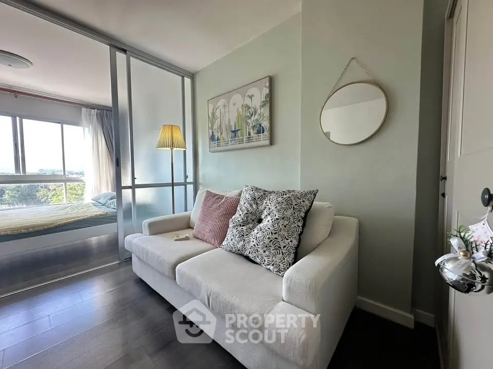 Chic modern living room with cozy sofa and stylish decor, adjacent to a bright bedroom with a scenic view.