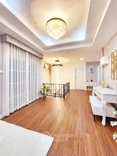 Luxurious interior with elegant chandelier and hardwood floors in a spacious living area.