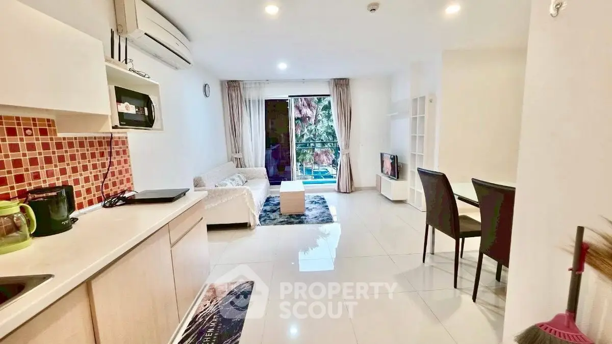 Modern open-plan living room with kitchen and balcony view