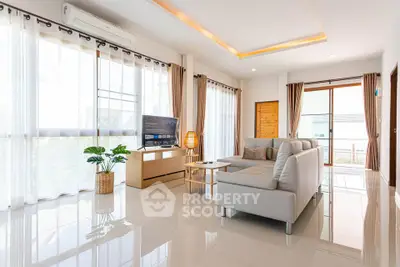 Spacious modern living room with sleek furniture and large windows for natural light.