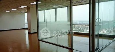 Spacious office space with glass partitions and panoramic city views.