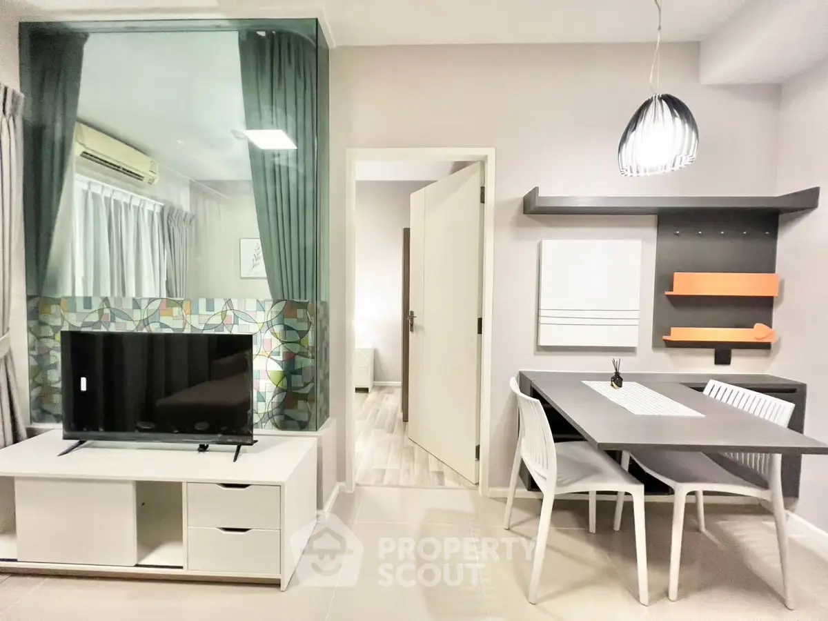 Modern living room with stylish dining area and TV setup, featuring contemporary decor and open layout.