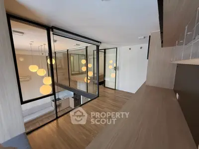 Modern open-plan living space with stylish lighting and wooden flooring