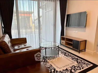 Modern living room with leather sofa, glass coffee table, and wall-mounted TV in a stylish apartment.