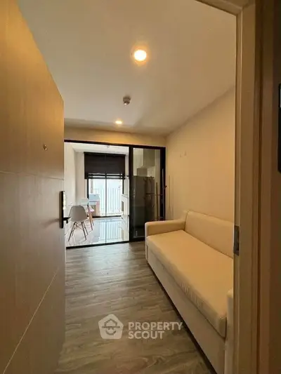 Modern apartment entrance with cozy living area and sleek wooden flooring.
