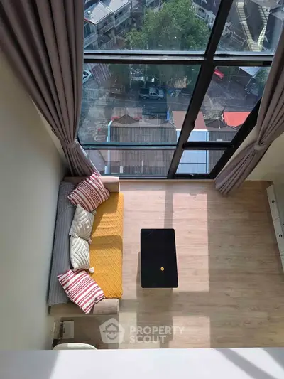 Stunning high-ceiling living room with floor-to-ceiling windows and cozy seating area.