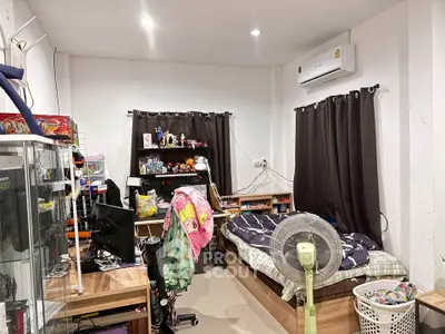 Cozy bedroom with modern decor and air conditioning, featuring a comfortable bed and ample storage space.