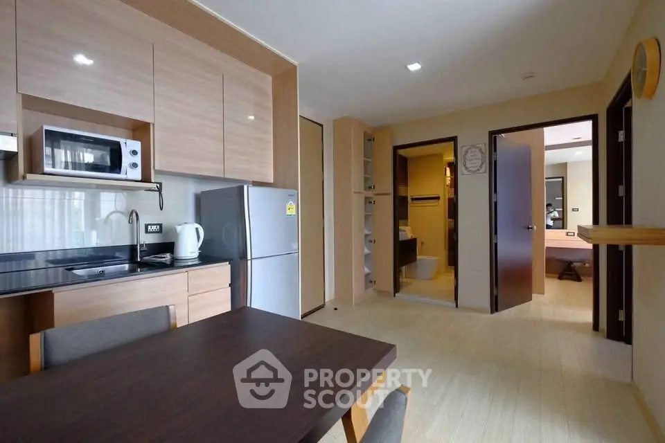 Modern kitchen and dining area with sleek appliances and wooden cabinetry