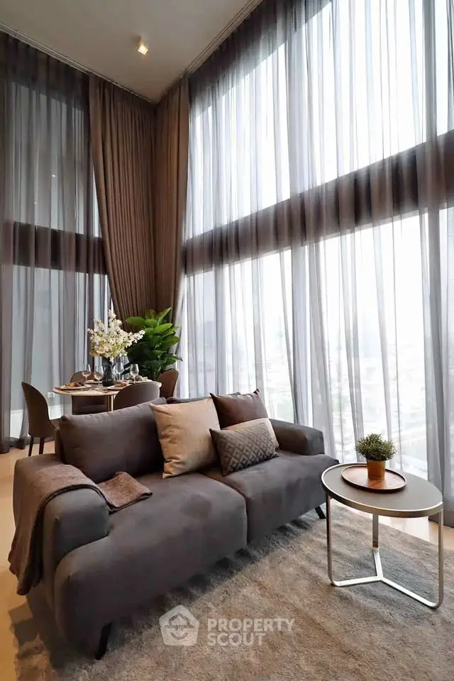 Luxurious living room with floor-to-ceiling windows and elegant decor in a modern apartment.