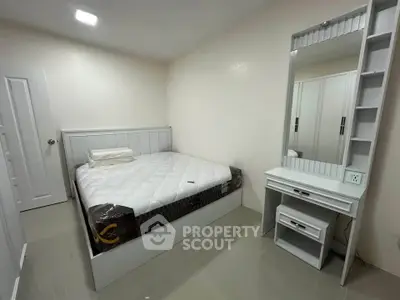 Modern bedroom with sleek design and ample storage space, featuring a comfortable bed and stylish vanity.
