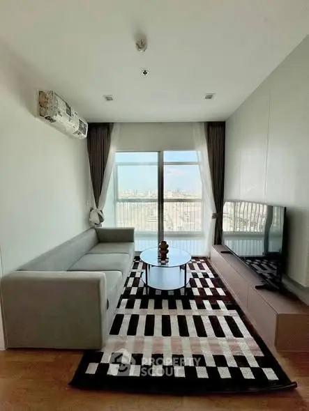 Modern living room with large window and city view, featuring stylish furniture and decor.