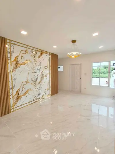 Luxurious living room with marble accent wall and modern lighting in elegant home.