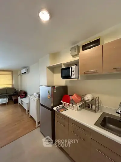 Modern kitchen with open layout and stainless steel appliances in cozy apartment