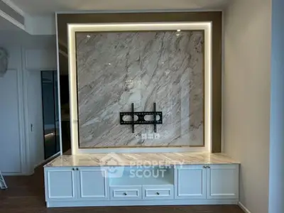 Elegant living room with marble accent wall and built-in cabinetry, perfect for modern home entertainment setup.