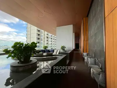 Luxurious high-rise balcony with stunning city views and modern seating area.