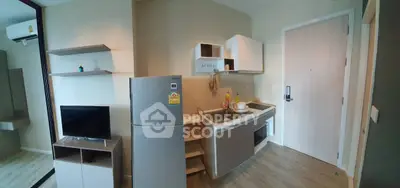 Modern compact kitchen with fridge and TV in cozy apartment