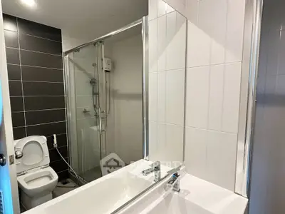 Modern bathroom with sleek design featuring a bathtub and glass-enclosed shower.