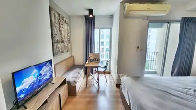 Modern studio apartment with balcony, featuring a cozy living area and stylish decor.