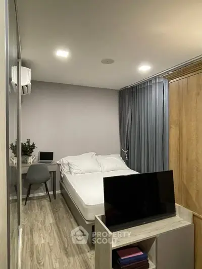 Modern bedroom with sleek design, featuring a cozy bed, stylish desk, and contemporary decor.