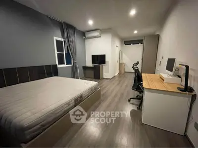 Modern bedroom with sleek furniture and workspace, ideal for urban living.