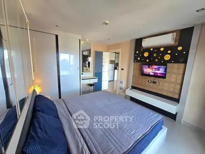 Modern bedroom with stylish decor and wall-mounted TV, featuring sleek storage solutions.