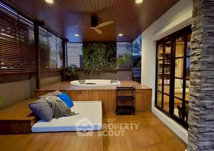Luxurious outdoor space with jacuzzi and cozy seating area, perfect for relaxation and entertainment.