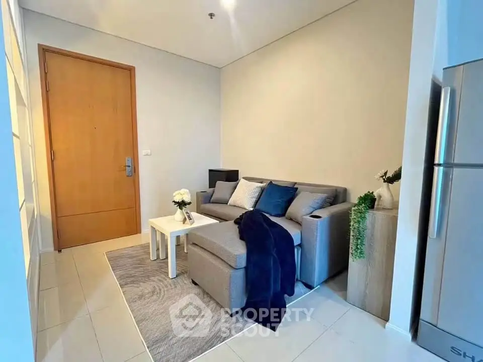 Cozy living room with modern sofa and stylish decor in a compact apartment.