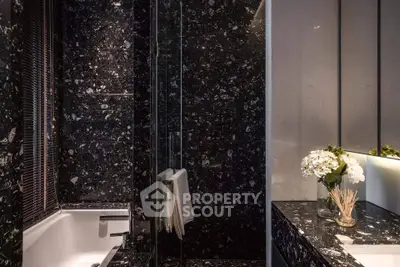 Luxurious black marble bathroom with elegant fixtures and ambient lighting