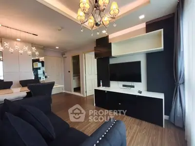 Modern living room with elegant chandelier and stylish black furniture