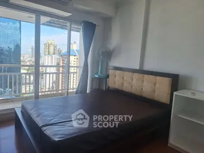 Spacious bedroom with city view and large windows in modern apartment