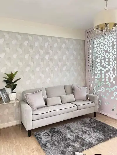 Stylish living room with modern decor, featuring a cozy gray sofa, elegant wallpaper, and chic lighting.