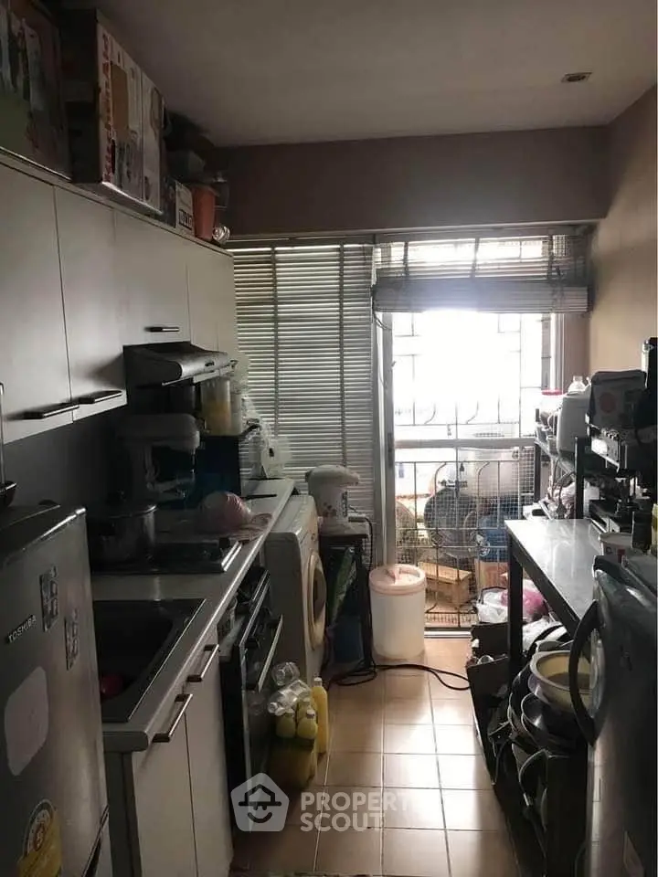 Compact kitchen with appliances and natural light from window.