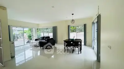Spacious living room with modern furniture and large windows offering natural light
