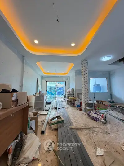 Spacious under-construction living room with modern ceiling lights and large windows.