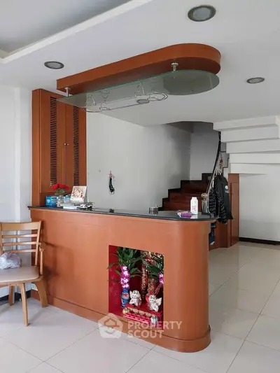 Modern interior with stylish staircase and wooden counter in a spacious living area.