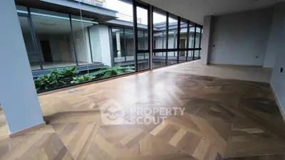 Spacious modern interior with large windows and elegant wooden flooring