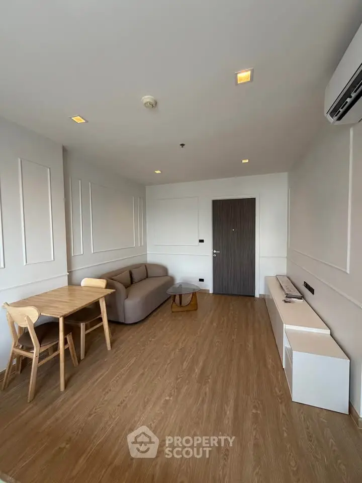 Modern living room with sleek furniture and wooden flooring in a stylish apartment.