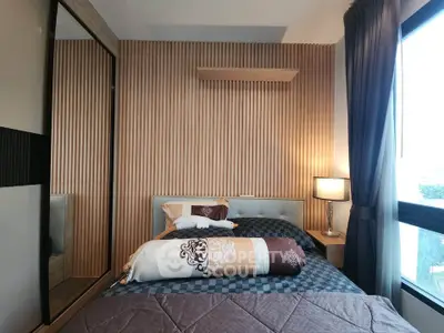 Modern bedroom with stylish decor and large window offering natural light.