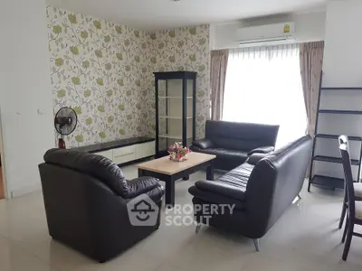 Stylish living room with leather sofas and floral wallpaper, perfect for cozy gatherings.