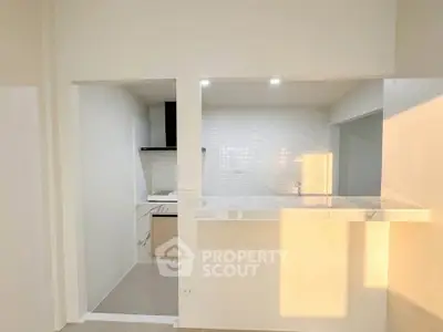 Modern kitchen with open layout and sleek design, featuring a breakfast bar and tiled backsplash.