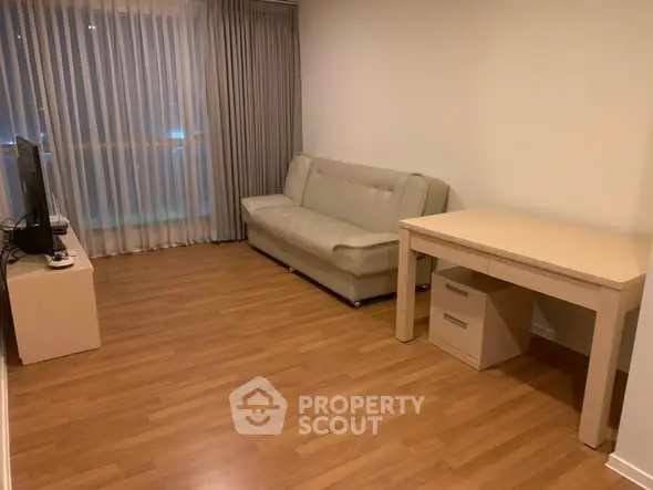 Cozy living room with wooden flooring, sofa, and TV setup for modern comfort.