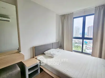 Modern bedroom with large window offering city view, featuring minimalist decor and natural light.
