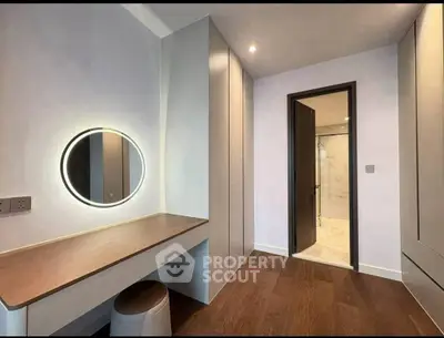 Modern bedroom with sleek vanity and ensuite bathroom in luxury apartment