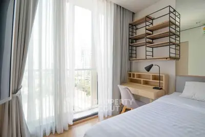 Bright bedroom with large window, modern desk, and stylish shelving in a high-rise apartment.